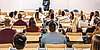 Lecturing room with students and a professor standing in the front