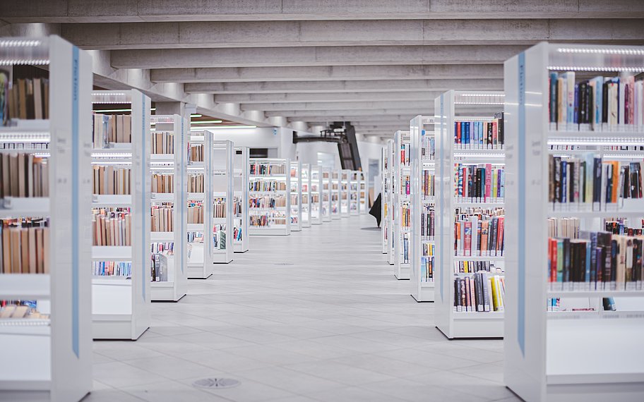 Foto: Weiße Holzregale mit Büchern in einer Bibliothek. © Ryunosuke Kikuno | unsplash.com