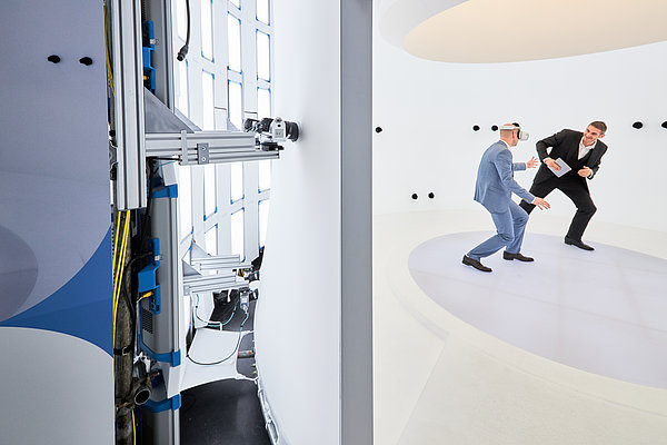 © Volucap Photo: Two people wearing virtual reality goggles stand in the studio. © Volucap