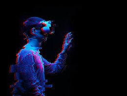 Foto: Ein Mann benutzt ein Virtual-Reality-Brille. Bild mit Glitch-Effekt.