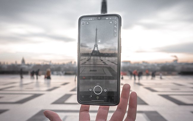 mit einem Smartphone wird der Eifelturm fotografiert