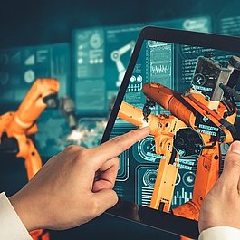 Foto: Ein Ingenieur steuert Roboterarme mithilfe der Augmented-Reality-Industrietechnologie.