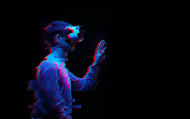 Foto: Ein Mann benutzt ein Virtual-Reality-Brille. Bild mit Glitch-Effekt.