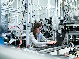 Ingenieurin mit Laptop in Werkstatt