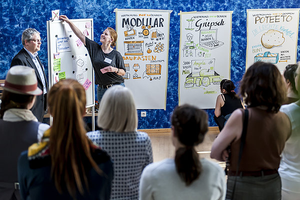 Foto: Workshop Kreativwirtschaft - Personen stehen vor einer Leinwand mit Flipcharts. © WFBB