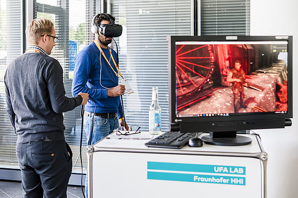 Foto: Person mit einer Virtual-Reality-Brille. Im Vordergrund ein Monitor, der zeigt was die Person durch die Brille sieht. © WFBB | David Marschalsky